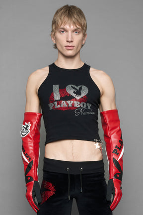 model wearing red and white Playboy x NAMILIA vegan leather gloves and mesh pants with white panels.