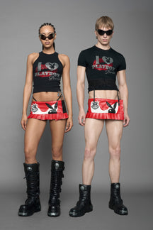 model wearing vegan leather NAMILIA x playboy pleated mini skirt with velcro closure