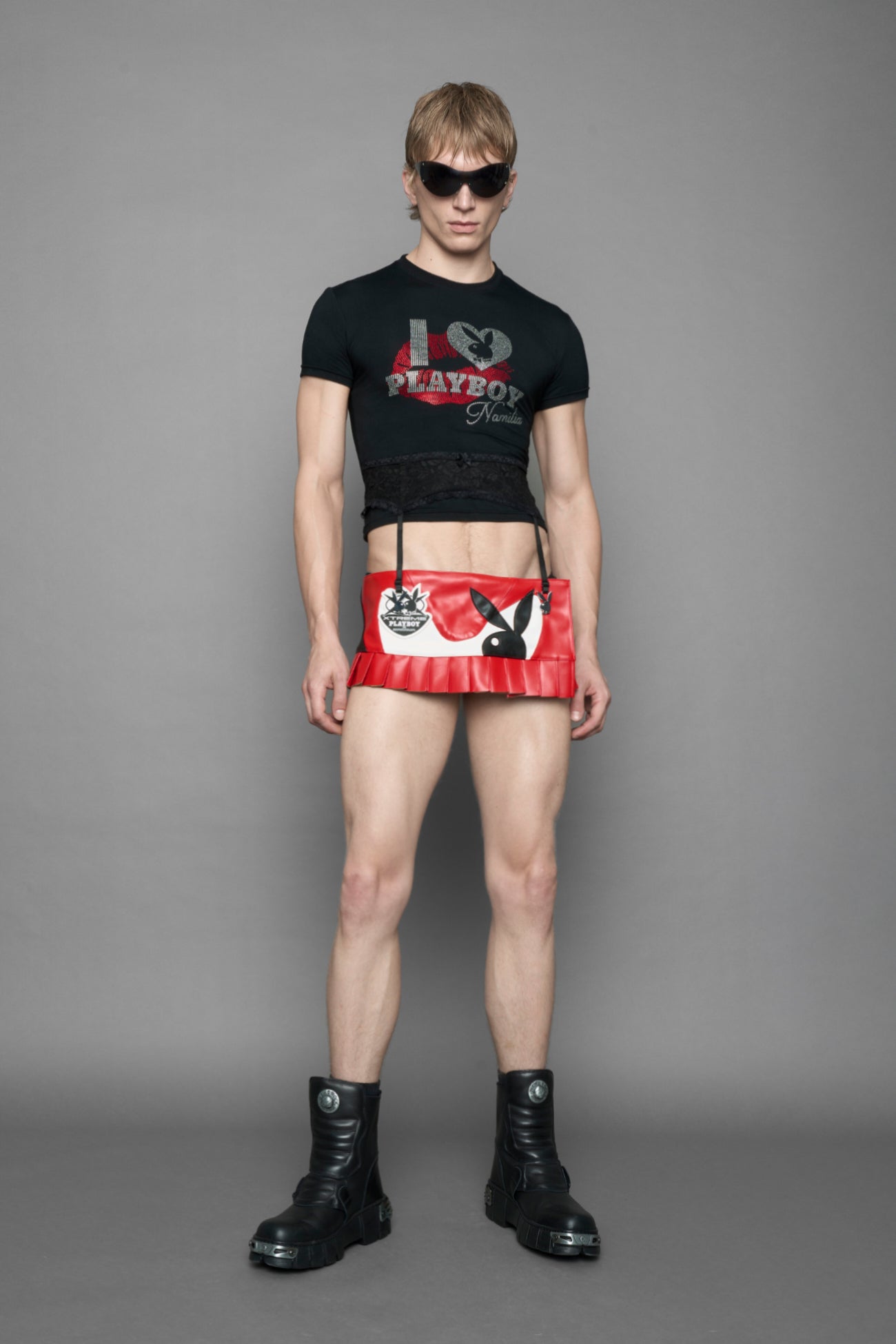 model wearing vegan leather NAMILIA x playboy pleated mini skirt with velcro closure