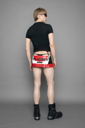 model wearing vegan leather NAMILIA x playboy pleated mini skirt with velcro closure