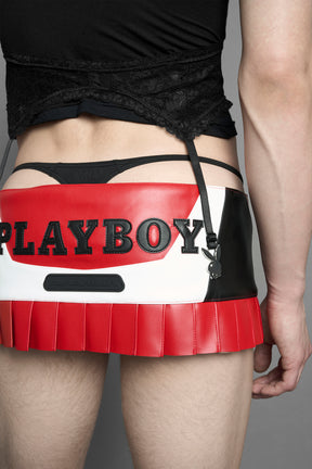 model wearing vegan leather NAMILIA x playboy pleated mini skirt with velcro closure
