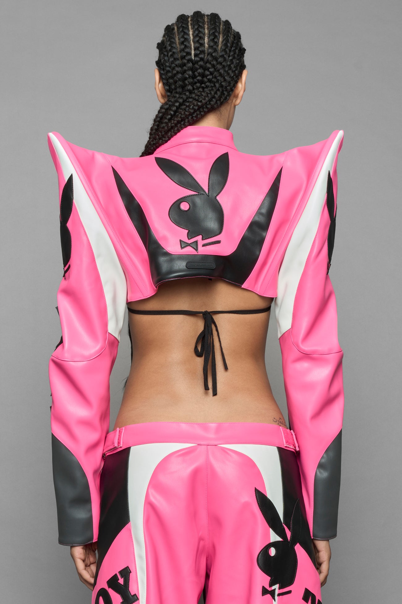 model wearing pink white vegan leather NAMILIA x PLAYBOY crop bolero jacket with sharp shoulder design 