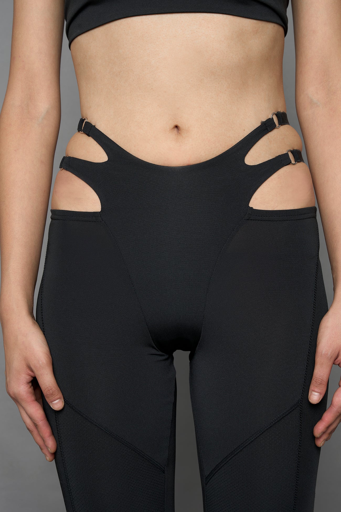 Model wearing black leggings with cut out detail